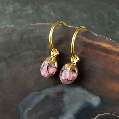Roze edelstenen oorbellen met rhodoniet en goud edelstaal, oorringen met roze edelstenen hangertje liggend in schelp
