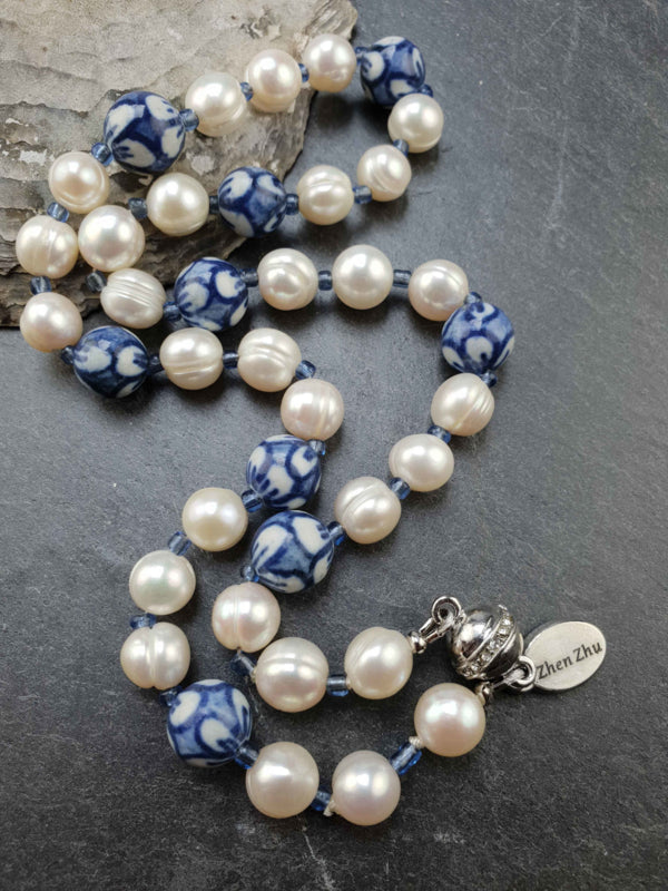 Zoetwater parelketting met witte parels, kralen met Delfts blauw motief en magneetslotje liggend op leisteen | Hollands Glorie Round Flower White