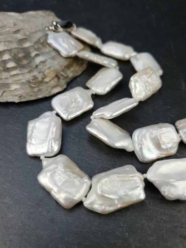 Witte zoetwater parelketting met vierkante parels en sterling zilver (925) liggend op steen | Rena