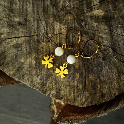 Witte parelmoeren oorbellen met goud edelstaal liggend op hout | Little Good Luck Gold
