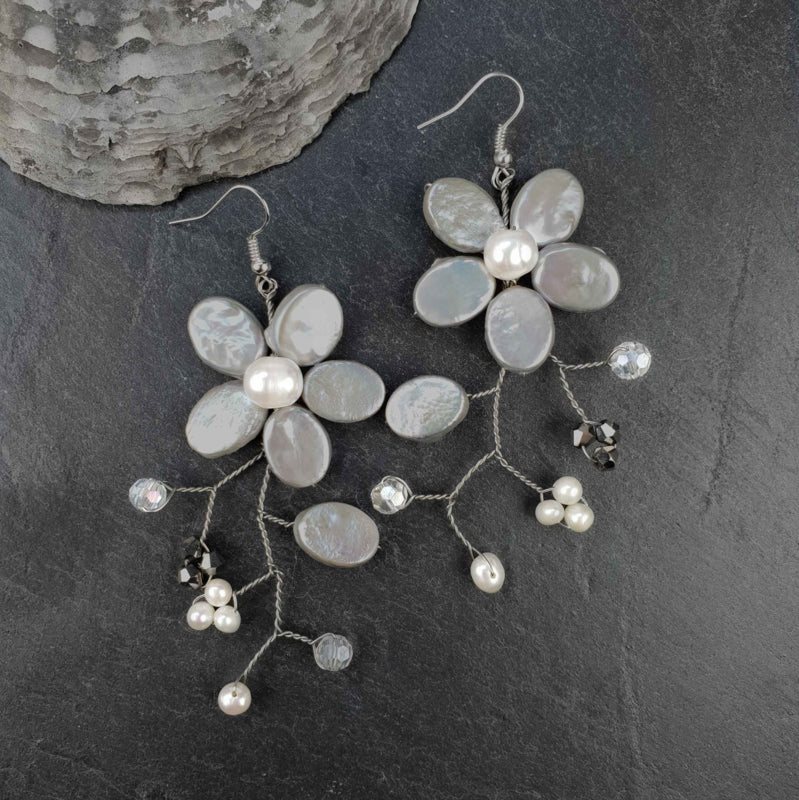 Lange zoetwater parel oorbellen met grijze en witte parels in bloem vorm en sterling zilveren (925) oorbel haakjes liggend op leisteen | Long Grey Flower Pearl