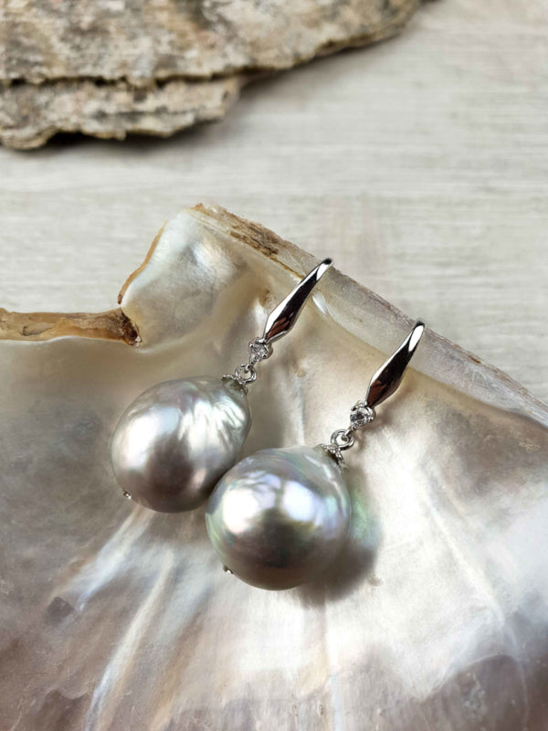 Grijze zoetwater parel oorbellen met sterling zilveren oorbelhaakjes en stras steentje liggend in schelp | Bling Kasumi Grey Pearl