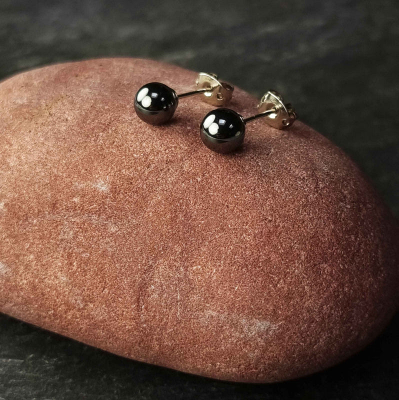 Zwarte edelstenen oorbellen met hematiet stenen 6 mm liggend op rode steen, zwarte hematiet oorknopjes 6 mm liggend op rode steen