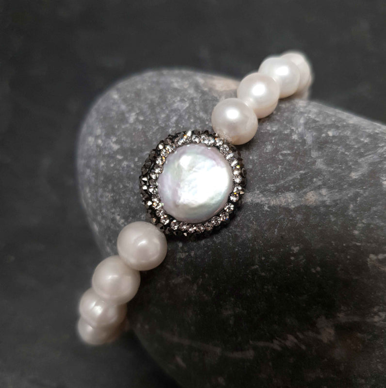 Wit zoetwater parel armband met stras steentjes, elastisch, liggend op kei | Bling Coin Pearl