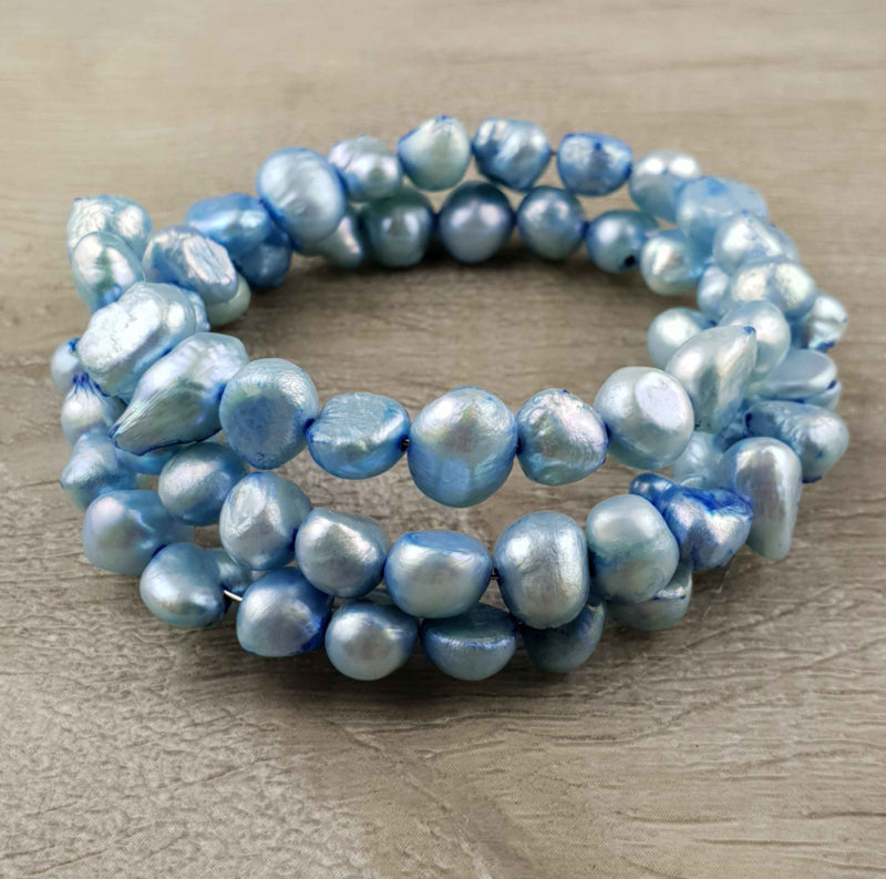 Zoetwater parel wikkel armband met aqua blauwe parels liggend op hout | Zen Aqua