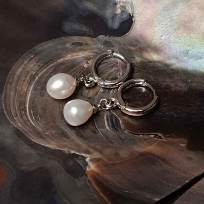 Witte zoetwater parel oorringen met witte parel en zilver edelstaal liggend in schelp zijaanzicht | Cadeau set met zoetwater parel oorbellen Bente