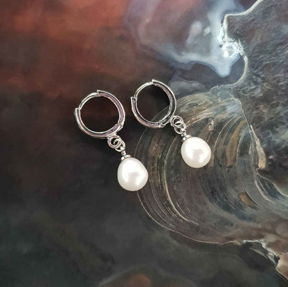 Witte zoetwater parel oorringen met witte parel en zilver edelstaal liggend in schelp bovenaanzicht | Cadeau set met zoetwater parel oorbellen Bente