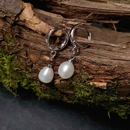 Witte zoetwater parel oorringen met witte parel en zilver edelstaal liggen op hout | Cadeau set met zoetwater parel oorbellen Bente