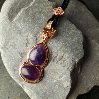 Paarse edelstenen ketting met amethist en rosé goud liggend op kei | Amethyst Gold