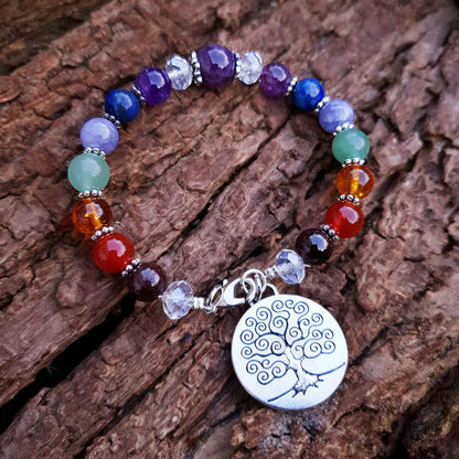 Edelstenen armband met verschillende soorten en kleuren edelstenen en levensboom bedeltje liggend op schors | Gemstone Chakra