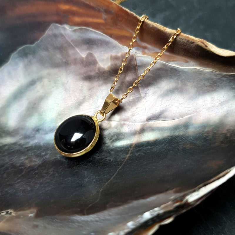 Zwarte edelstenen ketting met agaat en goud edelstaal liggend in schelp | set Black Agate Gold Round