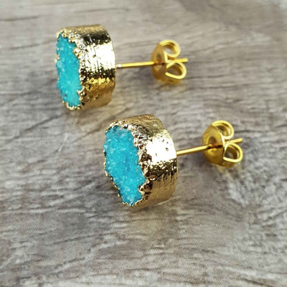 Edelstenen oorknoppen met aqua blauwe druzy agaat en goud liggend op hout zijaanzicht | Druzy Gold Deep Sky Blue