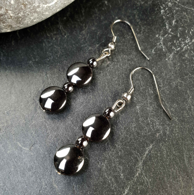 Zwarte edelstenen oorbellen met hematiet liggend op leisteen | set Hematite Coin (AO)