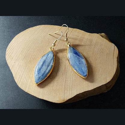 Blauw edelstenen oorbellen met kyaniet en goud edelstaal liggend op hout | Kyanite Long Gold