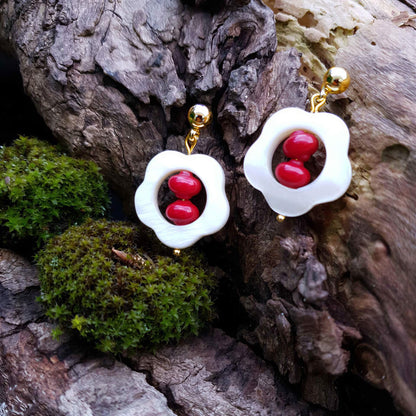 Rood koralen oorbellen met wit parelmoer in bloem vorm en goud edelstaal liggend op hout | Coral Flower