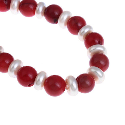 Detail van rood koralen armband met witte mother of pearl parel, elastisch | Carlijn