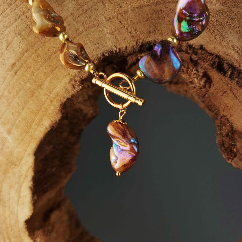 Slotje van bruin parelmoeren schelpen ketting met goud edelstaal met houten achtergrond| Shell AB Brown Gold
