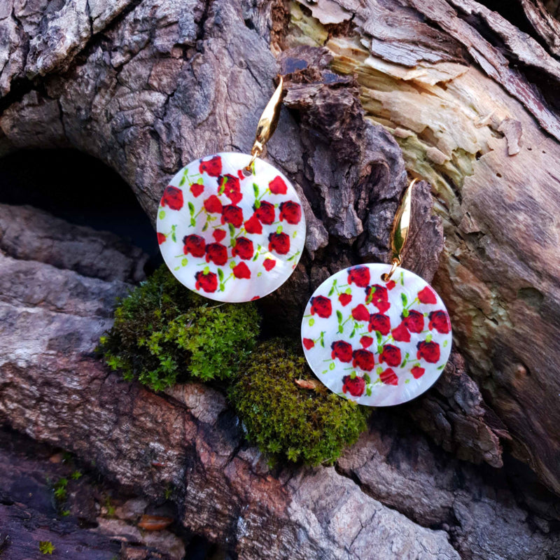 Parelmoeren oorbellen met wit parelmoer en goud kleurig edelstaal liggend op hout | Gold Shell Poppies