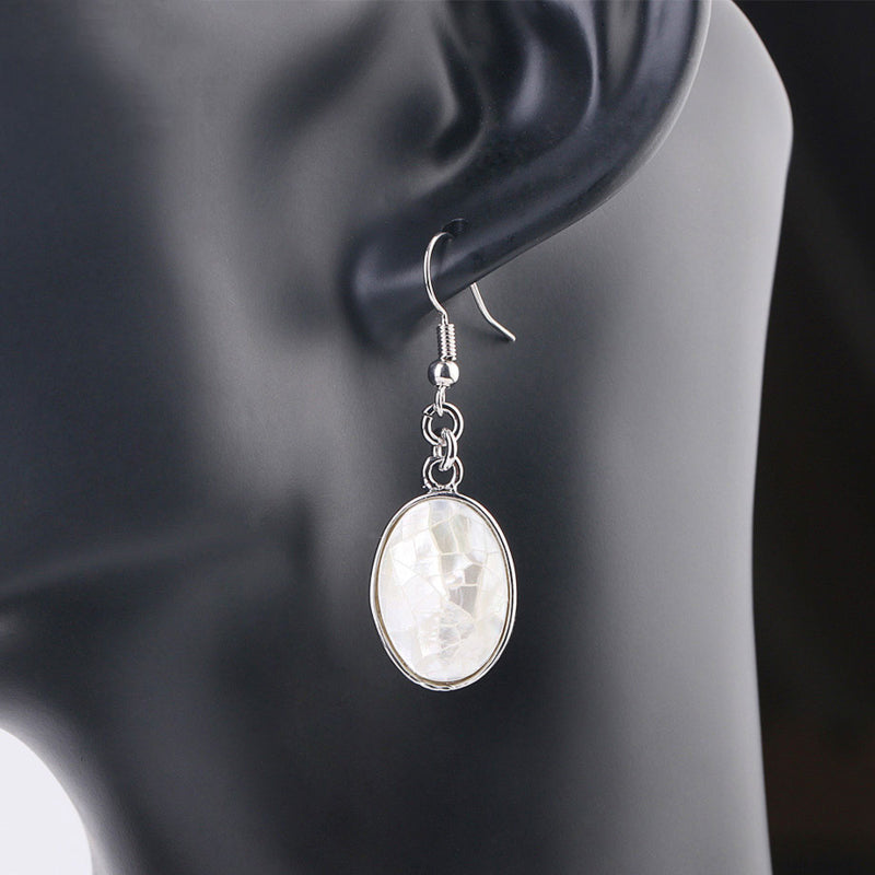 Witte ovale parelmoeren oorbellen met sterling zilver 925 op display | Oval White Shell Crackle