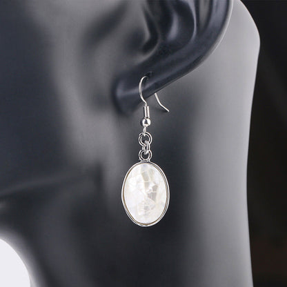 Witte ovale parelmoeren oorbellen met sterling zilver 925 op display | Oval White Shell Crackle