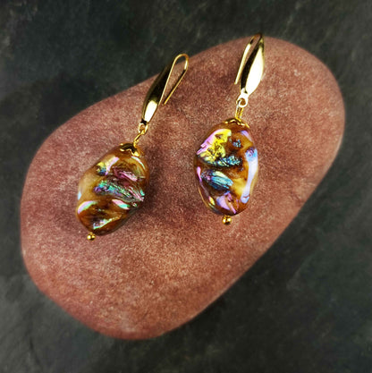 Bruine parelmoeren oorbellen met goud edelstaal liggend op rode steen  | Shell AB Brown Gold