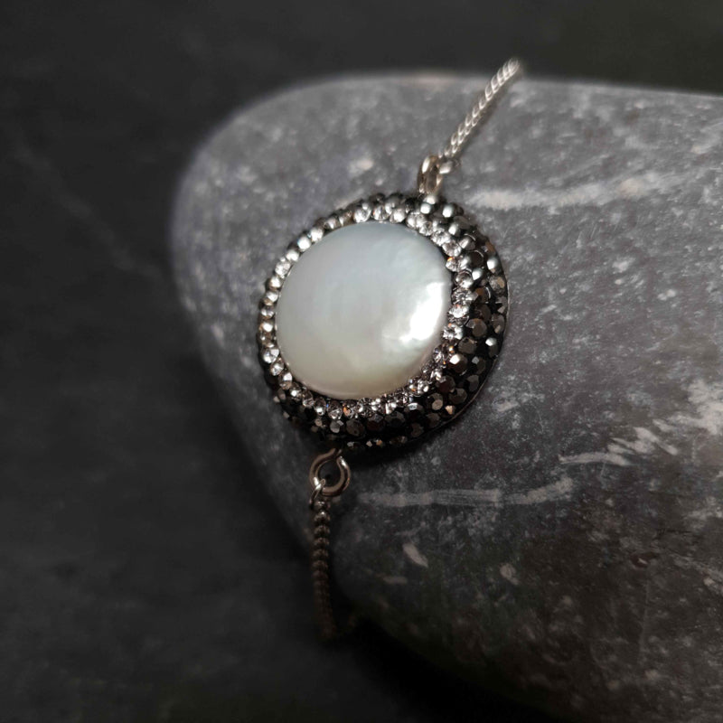 Wit zoetwater parel schuif armband met stras steentjes en edelstaal liggend op kei | Bright Minimal Silver Coin