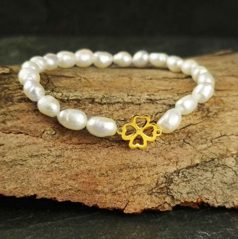 Wit zoetwater parel armband met een klavertje 4 van goud edelstaal met achtergrond hout | Good Luck Groot Klavertjje 4 Goud