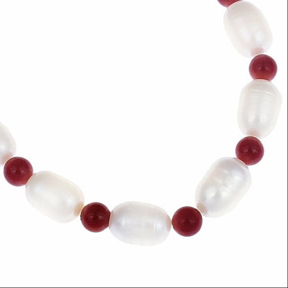 Detail van wit zoetwater parel armband met rood koraal, elastisch | Claudine