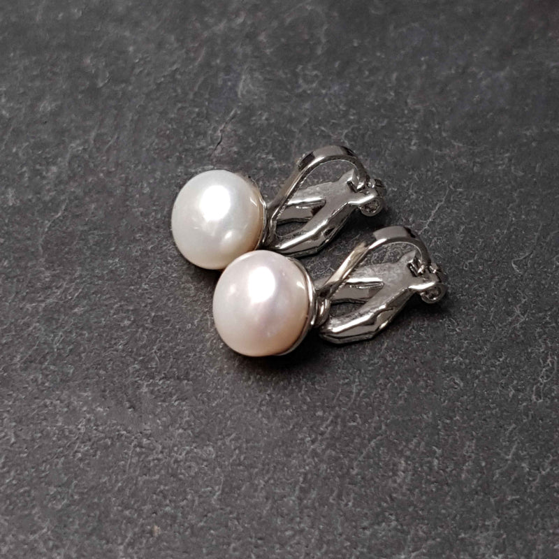 Witte zoetwater parel clips oorbellen liggend op leisteen | Cadeau set met zoetwater parel clips oorbellen Clip Pearl