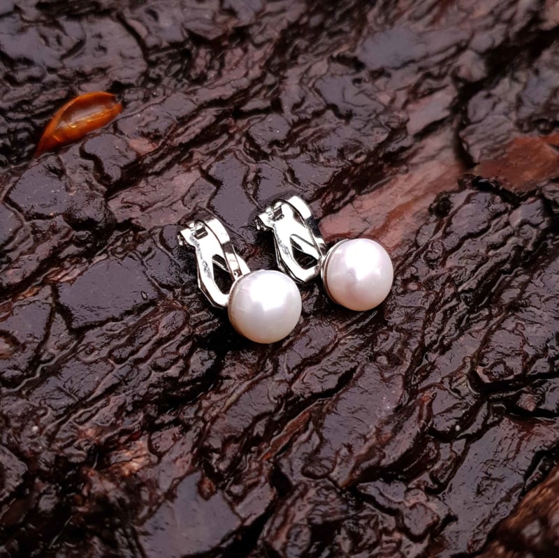 Witte zoetwater parel clips oorbellen liggend op hout | Cadeau set met zoetwater parel clips oorbellen Clip Pearl