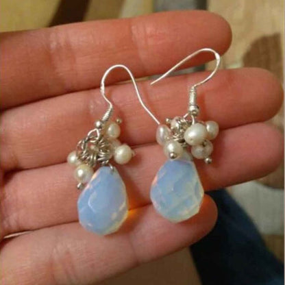 Witte zoetwater parel oorbellen met zee opaal en sterling zilver (925) liggend in hand | Coline