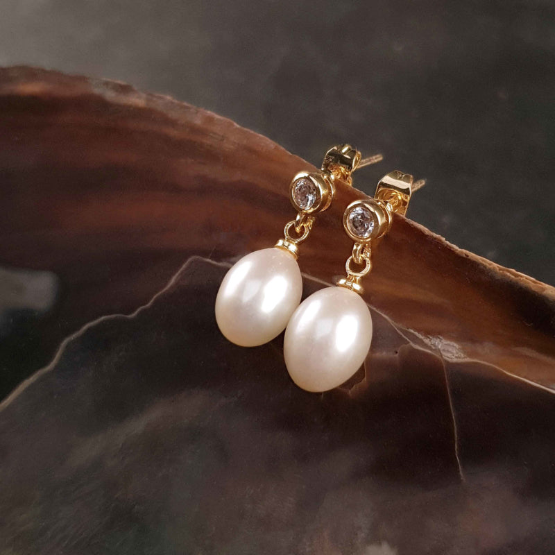Witte zoetwater parel oorbellen met stras steentje, parel oorknopjes hangend aan schelp, zijaanzicht | Bling Gold White Pearl