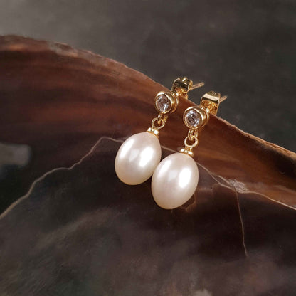 Witte zoetwater parel oorbellen met stras steentje, parel oorknopjes hangend aan schelp, zijaanzicht | Bling Gold White Pearl