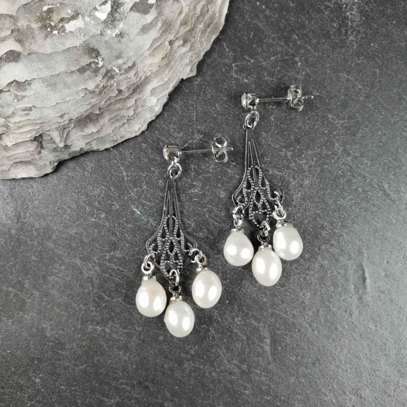 Witte zoetwater parel oorbellen met stras steentje liggend op leisteen | Bling Pearl Jugenstil