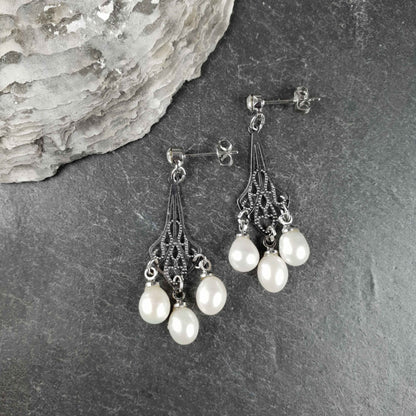 Witte zoetwater parel oorbellen met stras steentje liggend op leisteen | Bling Pearl Jugenstil