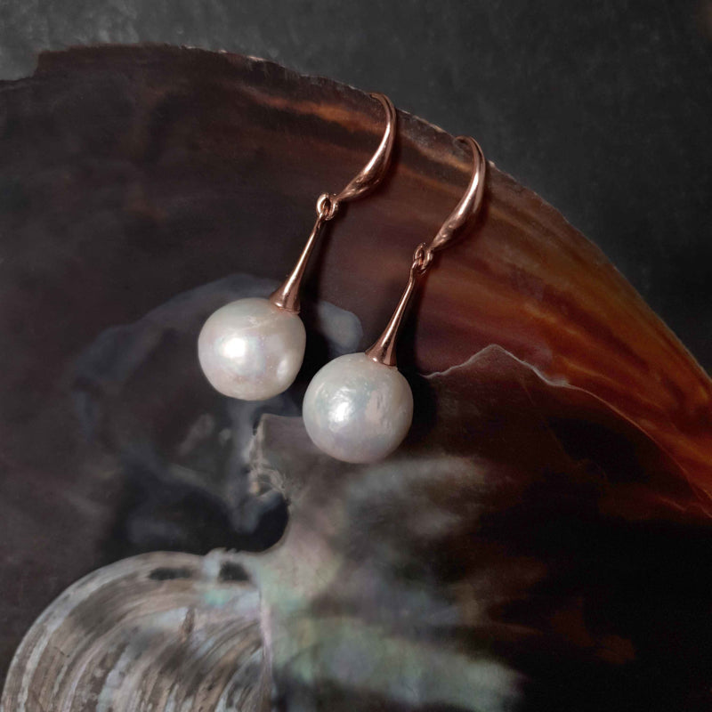 Lange witte zoetwater parel oorbellen met rose goud kleur liggend in schelp | Kasumi White Rose Gold