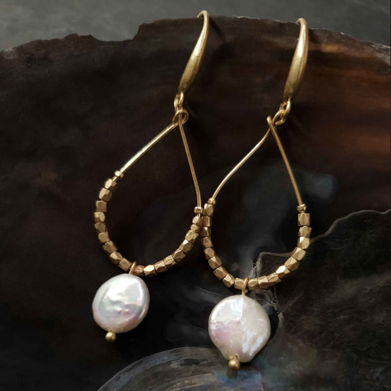 Lange witte zoetwater parel oorbellen met witte coin parels en goud hangend in schelp | Milany Gold