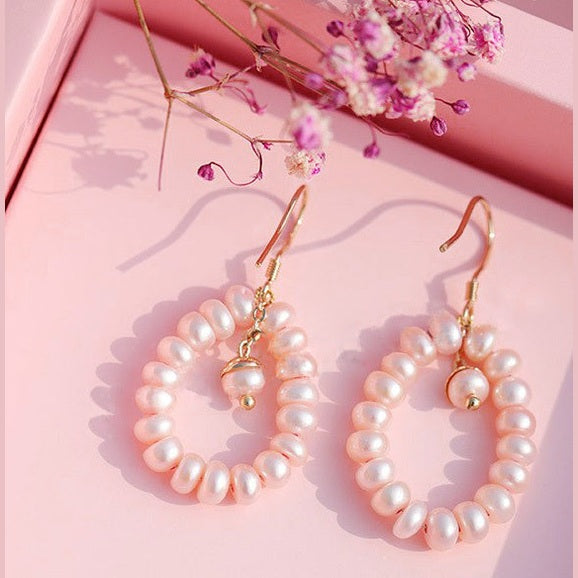 Lange zoetwater parel oorbellen met zalm roze parels en goud edelstaal met achtergrond | Zuyin