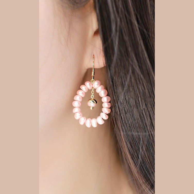Lange zoetwater parel oorbellen met zalm roze parels en goud edelstaal hangend in oor | Zuyin
