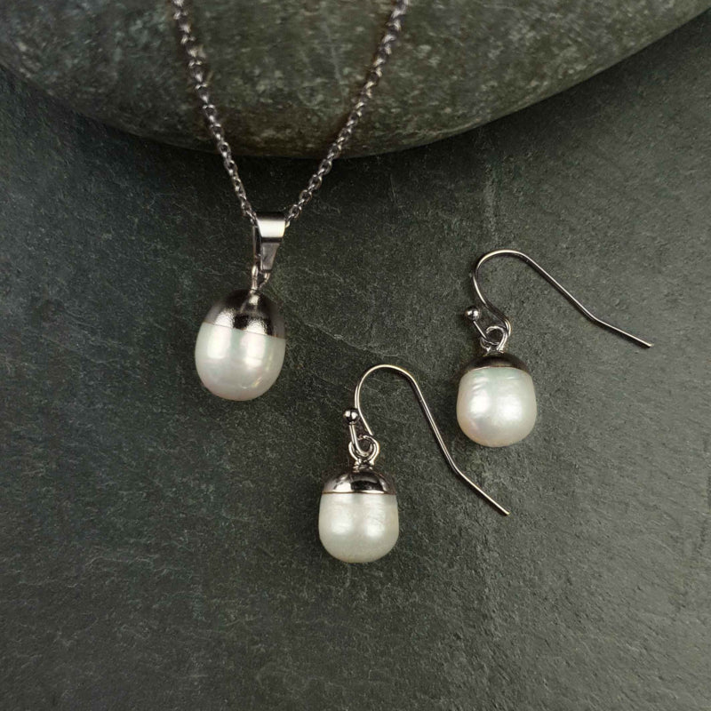 witte zoetwater parel set bestaande uit een parelketting en parel oorbellen met zilver edelstaal en parel hanger liggend op steen | set Silver Dip White Pearl