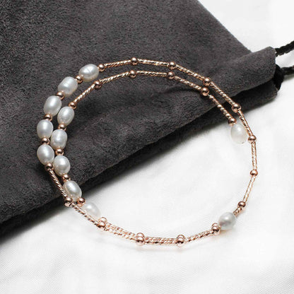 Zoetwater parel wikkel armband met witte parels en rose goud liggend op zakje | Wrap Rose White Pearl