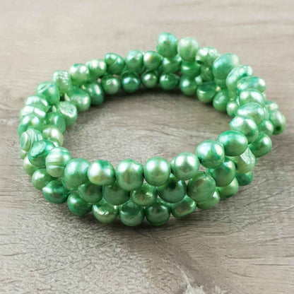 Zoetwater parel wikkelarmband met groene parels liggend op hout | Zen Green