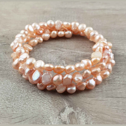 Zoetwater parel wikkel armband met zalm kleurige parels liggend op hout | Zen Peach