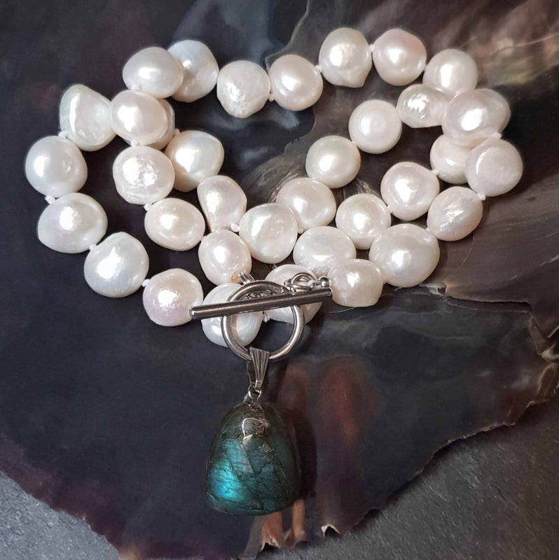 Witte zoetwater parelketting met labradoriet hanger en zilver edelstaal recht liggend in schelp| Toggle Big Pearl Labradorite