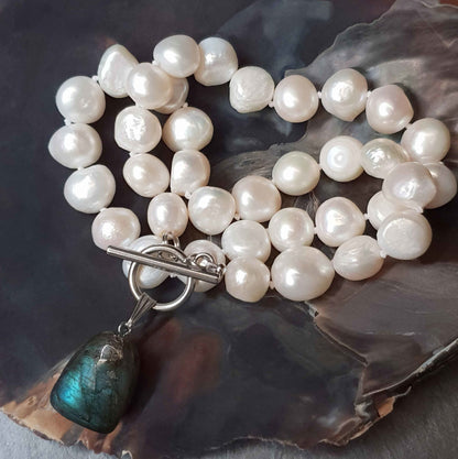 Witte zoetwater parelketting met labradoriet hanger en zilver edelstaal schuin in schelp | Toggle Big Pearl Labradorite