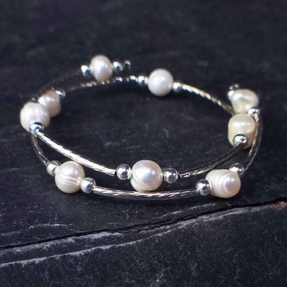 Wit zoetwater parel wikkel armband liggend op steen | Pearl Metal Wrap