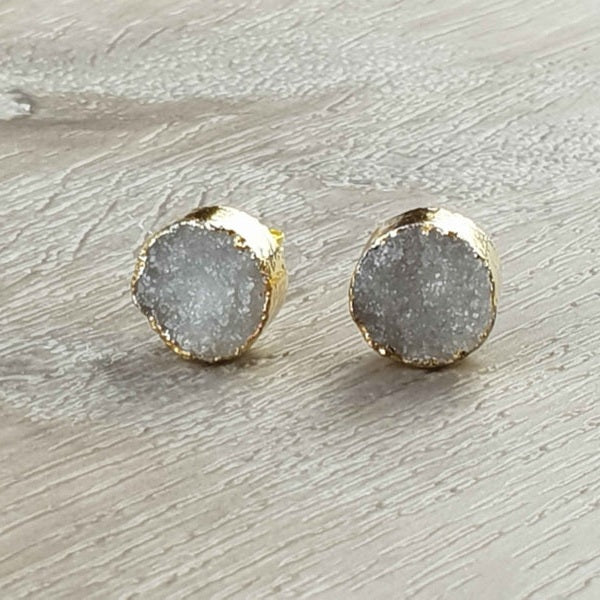 Edelstenen oorbellen met grijze druzy agaat en goud liggend op hout vooraanzicht | Druzy Gold Grey