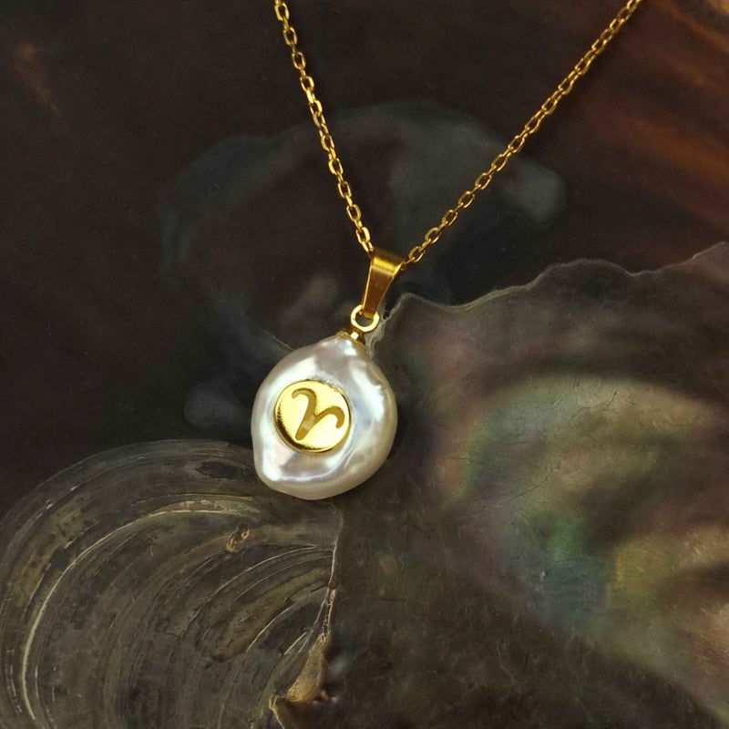 Witte zoetwater parelketting met parel hanger en symbool van sterrenbeeld Ram en goud edelstaal liggend in schelp | Gouden Sterrenbeeld Ram
