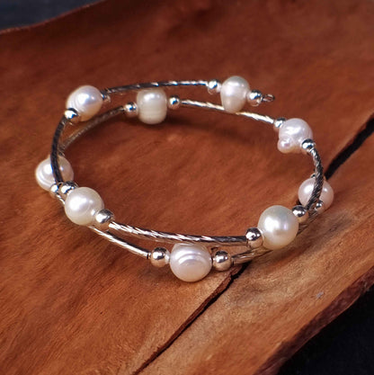 Wit zoetwater parel wikkelarmband liggend op schors | Pearl Metal Wrap