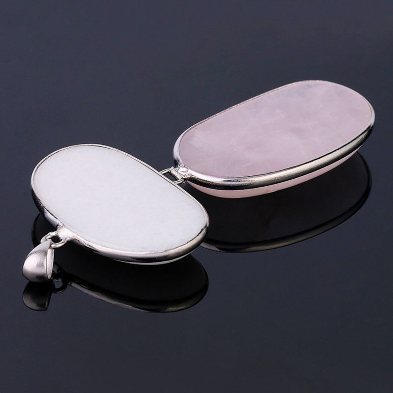 Detail van roze en witte edelstenen ketting met rozenkwarts hanger liggend op zwarte ondergrond | Rosé Quartz White Stone